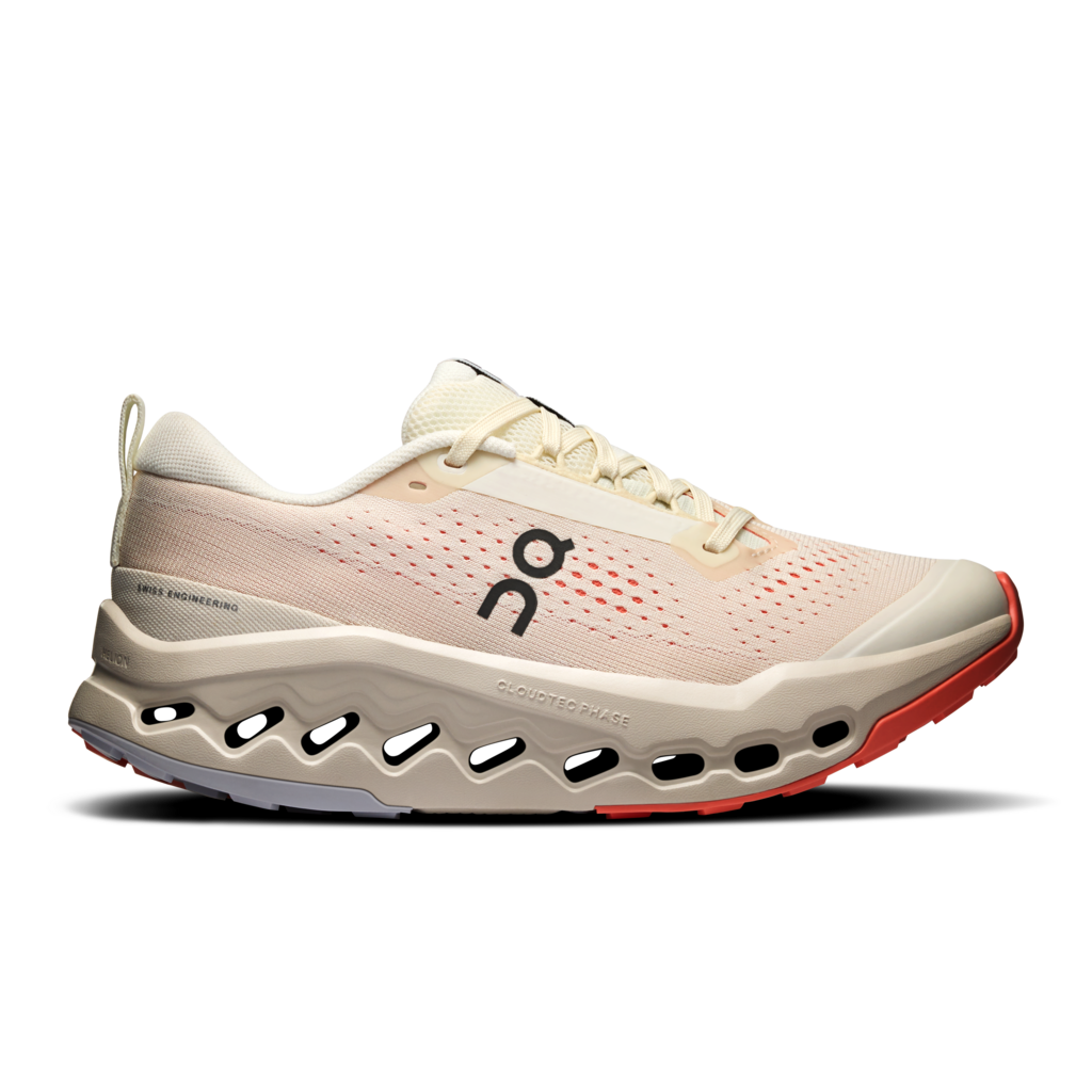Beige running shoe with red sole on a white background