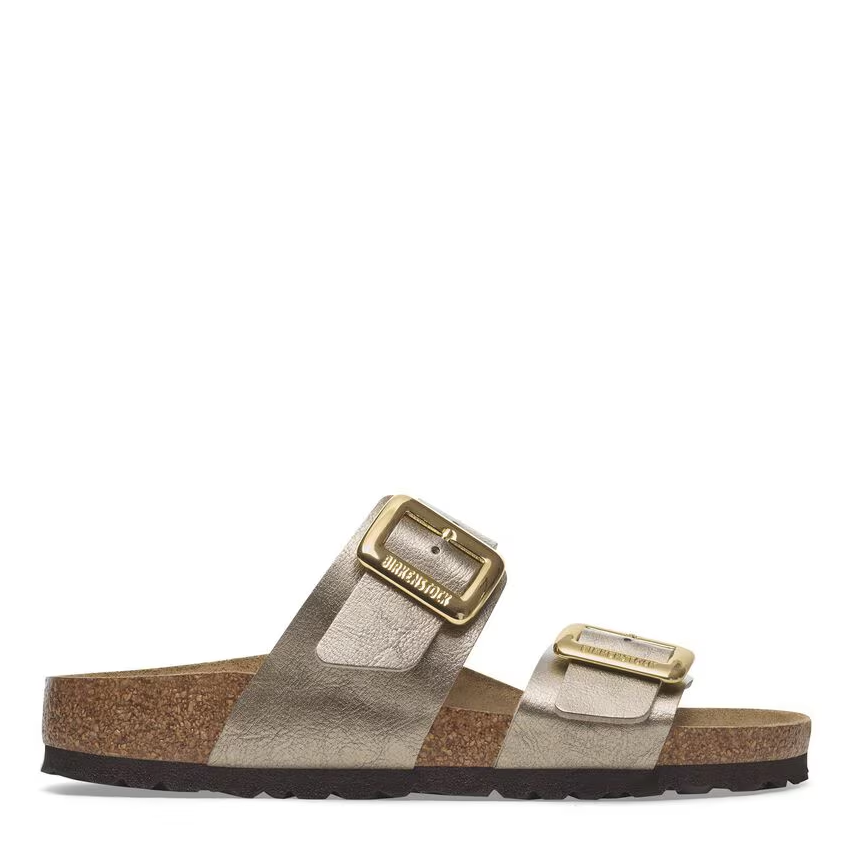 A pair of Birkenstock Sydney women's sandals with metallic buckle straps and a cork-latex footbed, in a side profile view.