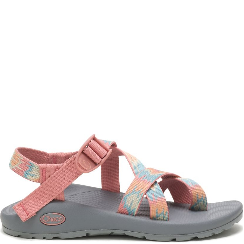 A pink women's sandal with adjustable straps and a multicolored floral design on the strap, featuring a gray sole and a toe-loop for control.
