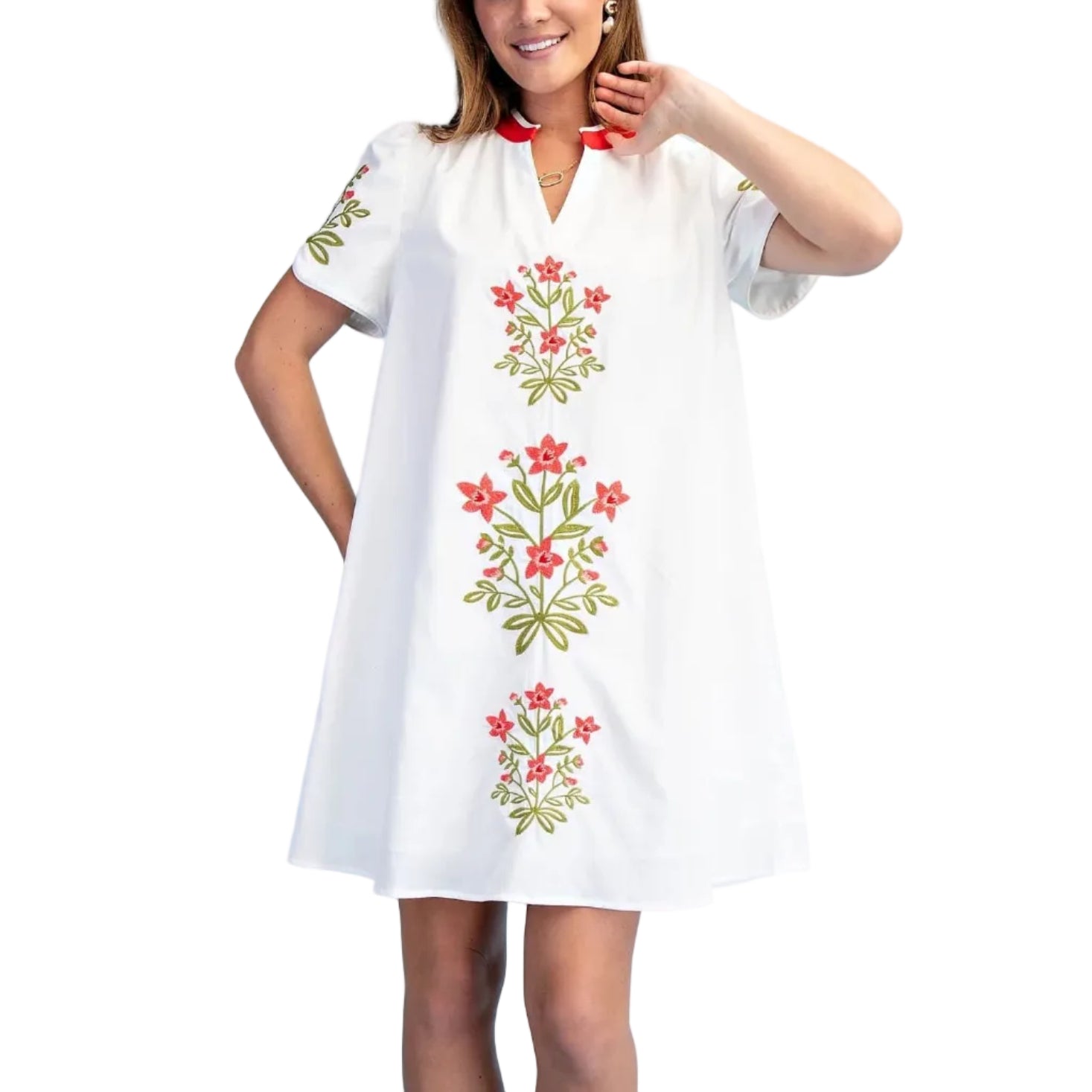 Woman wearing a white dress with floral embroidery on a light blue background