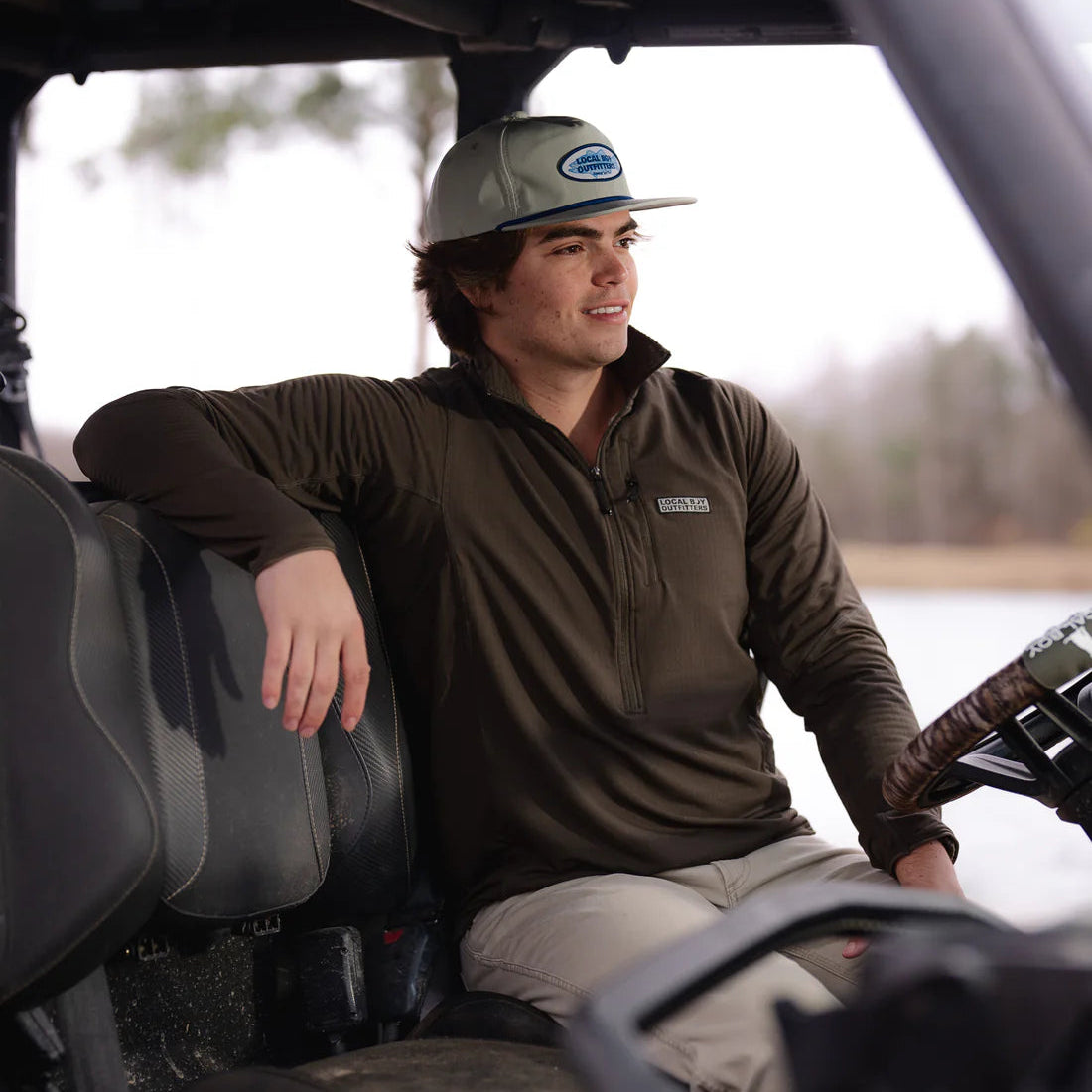 Man sitting inside a vehicle with a blurred natural background