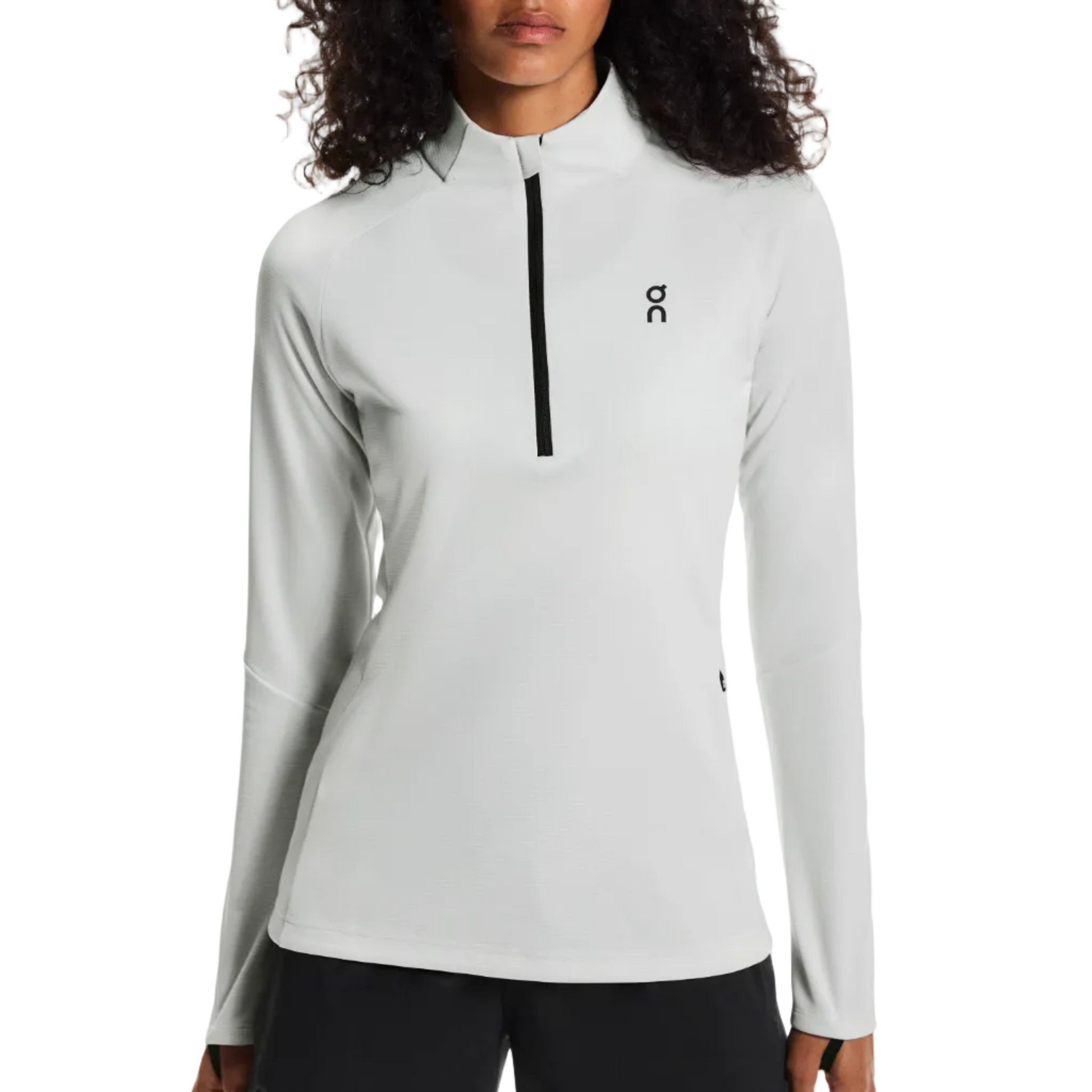 Woman wearing a light gray long-sleeve athletic top with a brand logo on a white background