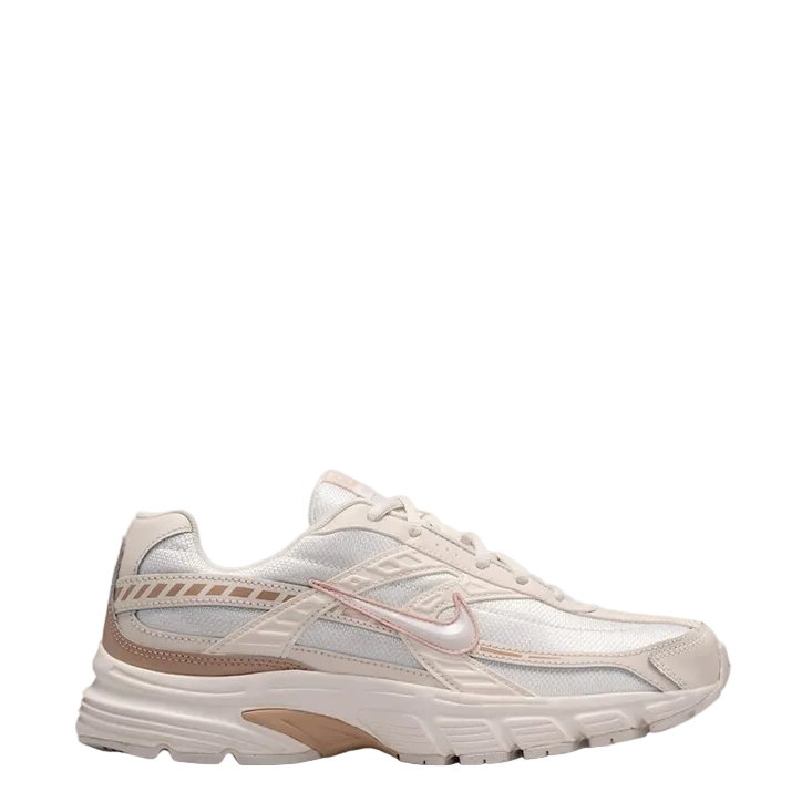 A Nike running shoe in a light cream and white colorway with dusty rose accents and a beige midsole, shown from a side profile on a light gray background.