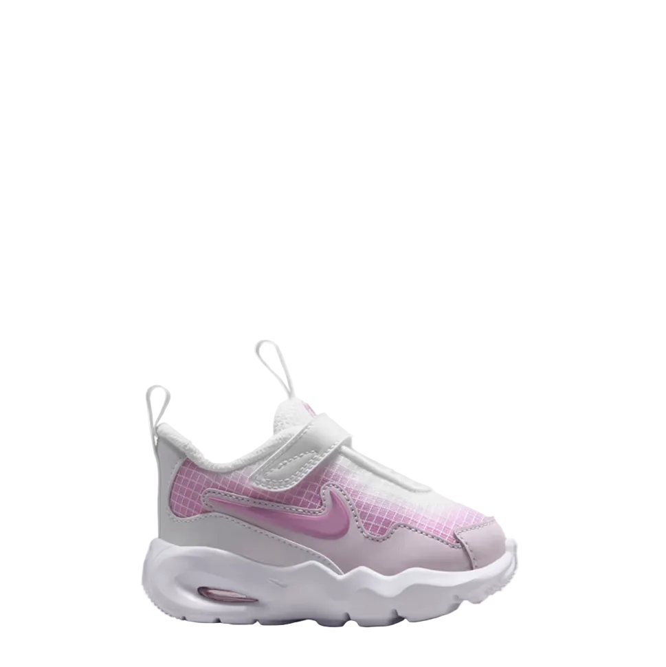 A Nike toddler sneaker in white and pink, featuring a hook-and-loop strap, a pink Swoosh, and a white textured sole, shown against a light gray gradient background.