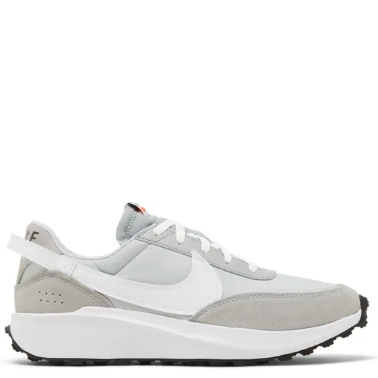 A Nike low-top sneaker in light gray and white, featuring a white Swoosh, white laces, a white heel strap, and a thick white midsole with a black outsole.