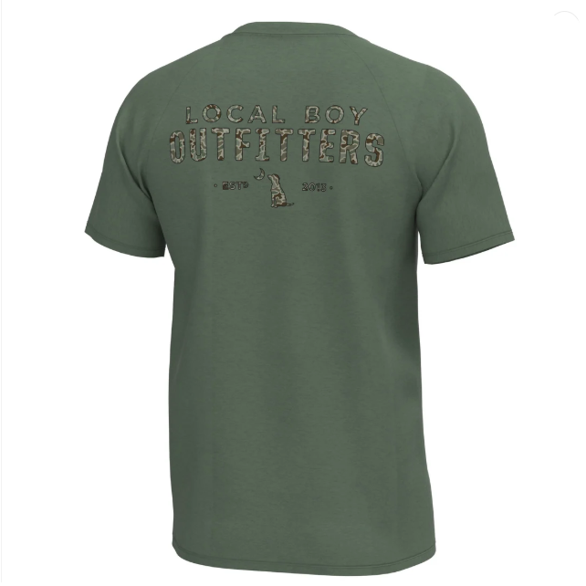 An olive green short-sleeve t-shirt shown from the back, featuring a distressed graphic that reads 'LOCAL BOY OUTFITTERS' in a camouflage pattern with a deer head logo and the years '1975' and '2018'.