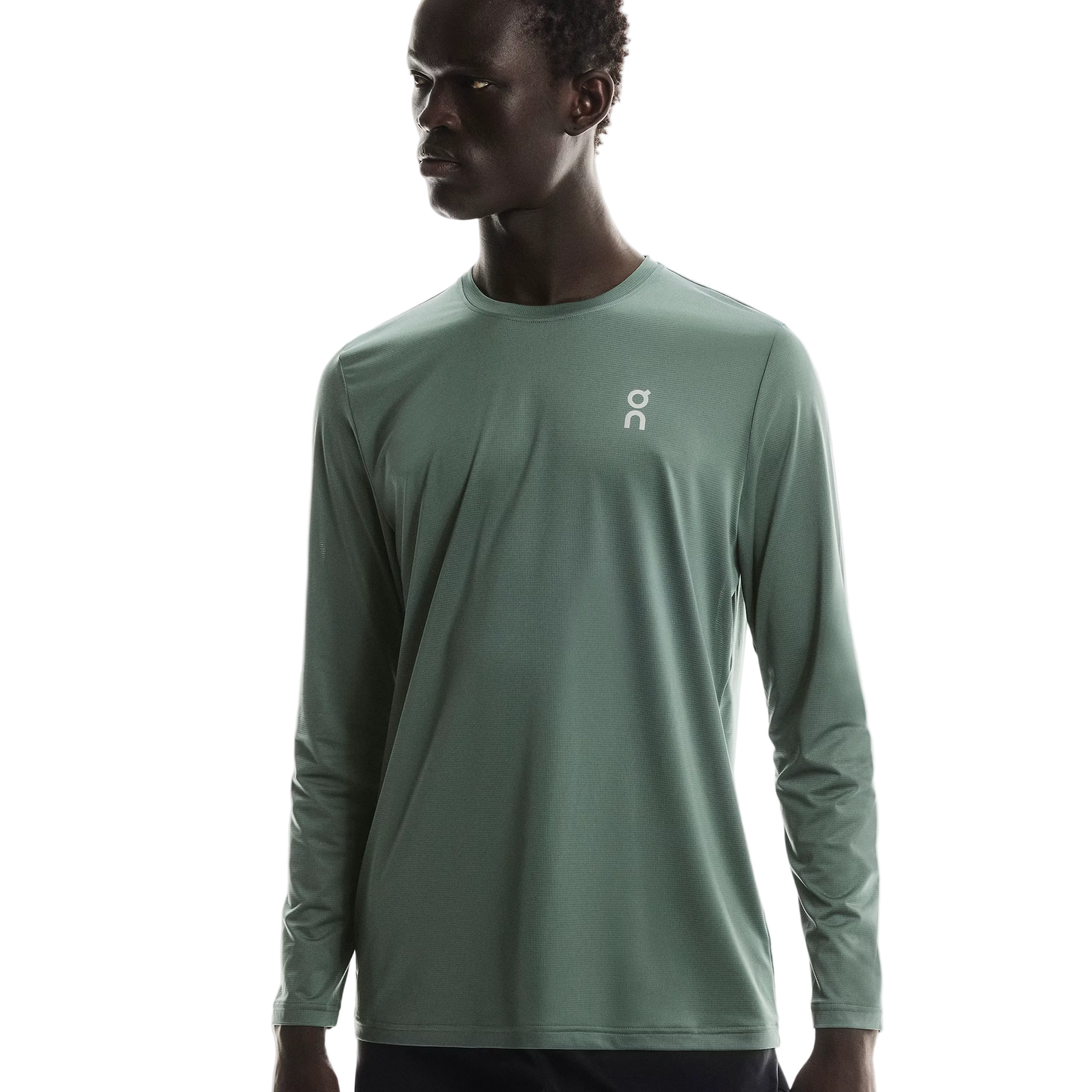 Person wearing a green long-sleeve athletic shirt with a logo on a white background