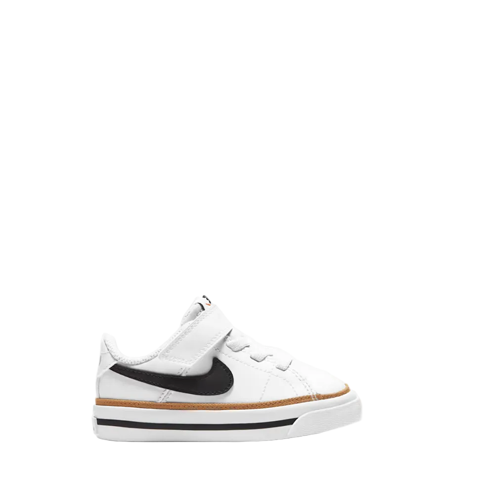 A white Nike sneaker for kids, featuring a black Swoosh logo, white laces, a white rubber sole with a black stripe, and a thin brown gum accent line.