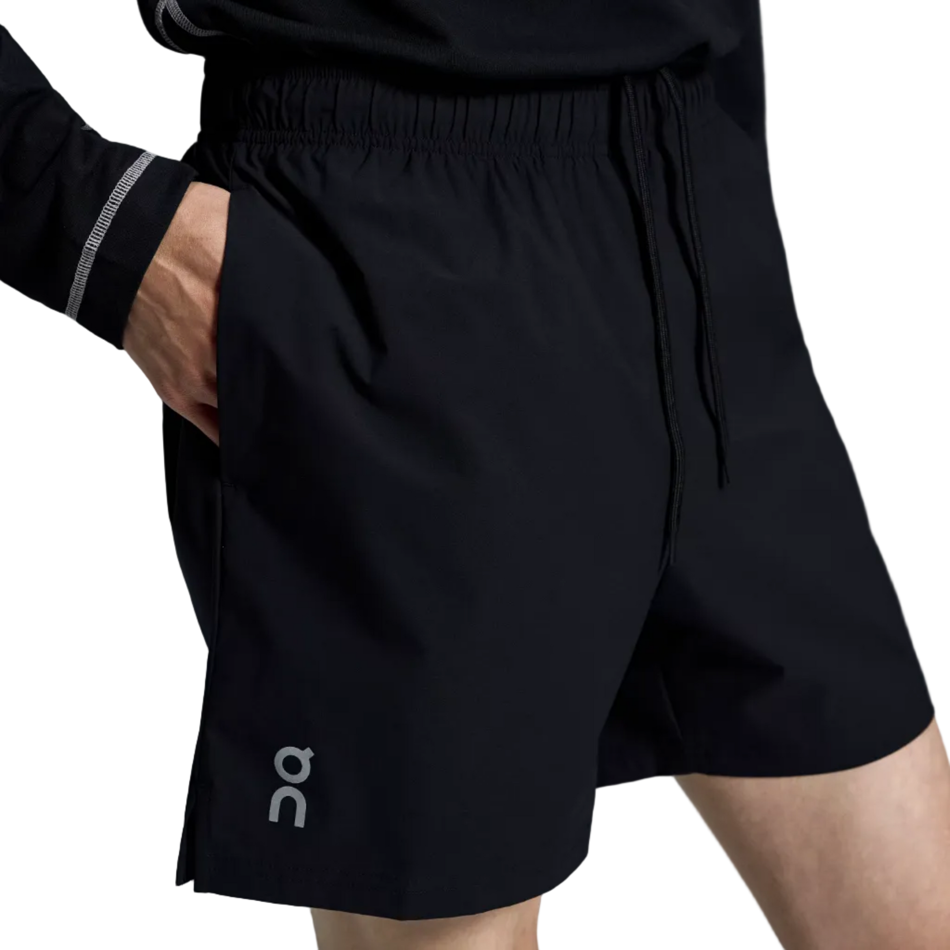 Person wearing black athletic shorts with a brand logo on a gray background
