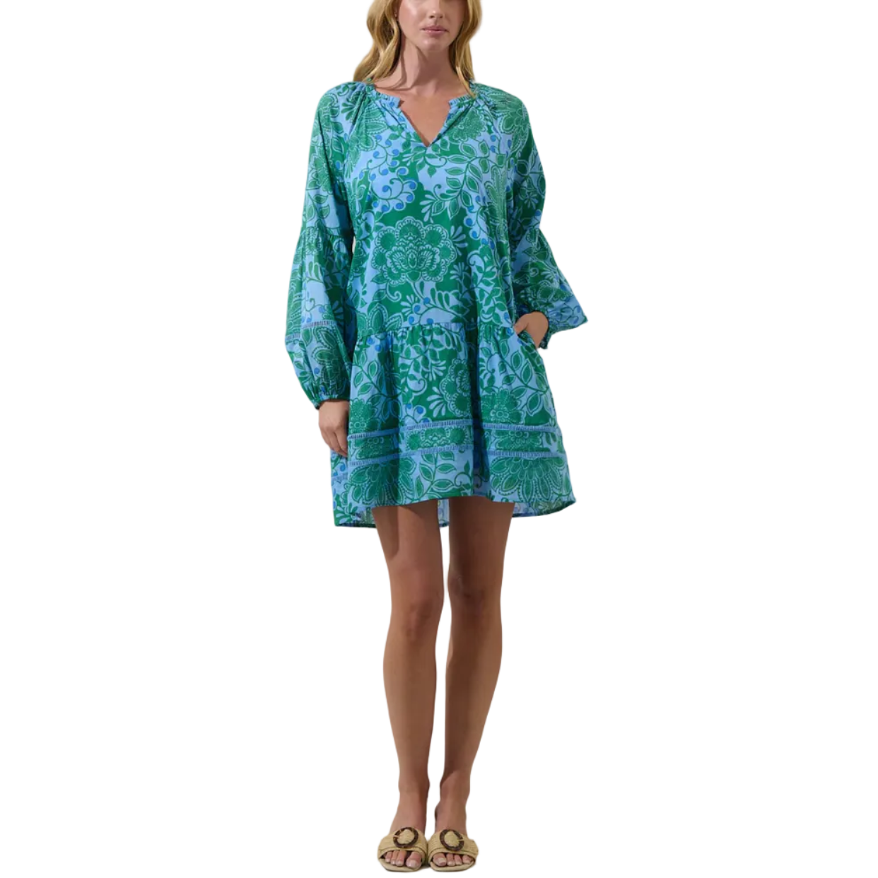 Woman wearing a green and blue patterned dress on a plain background