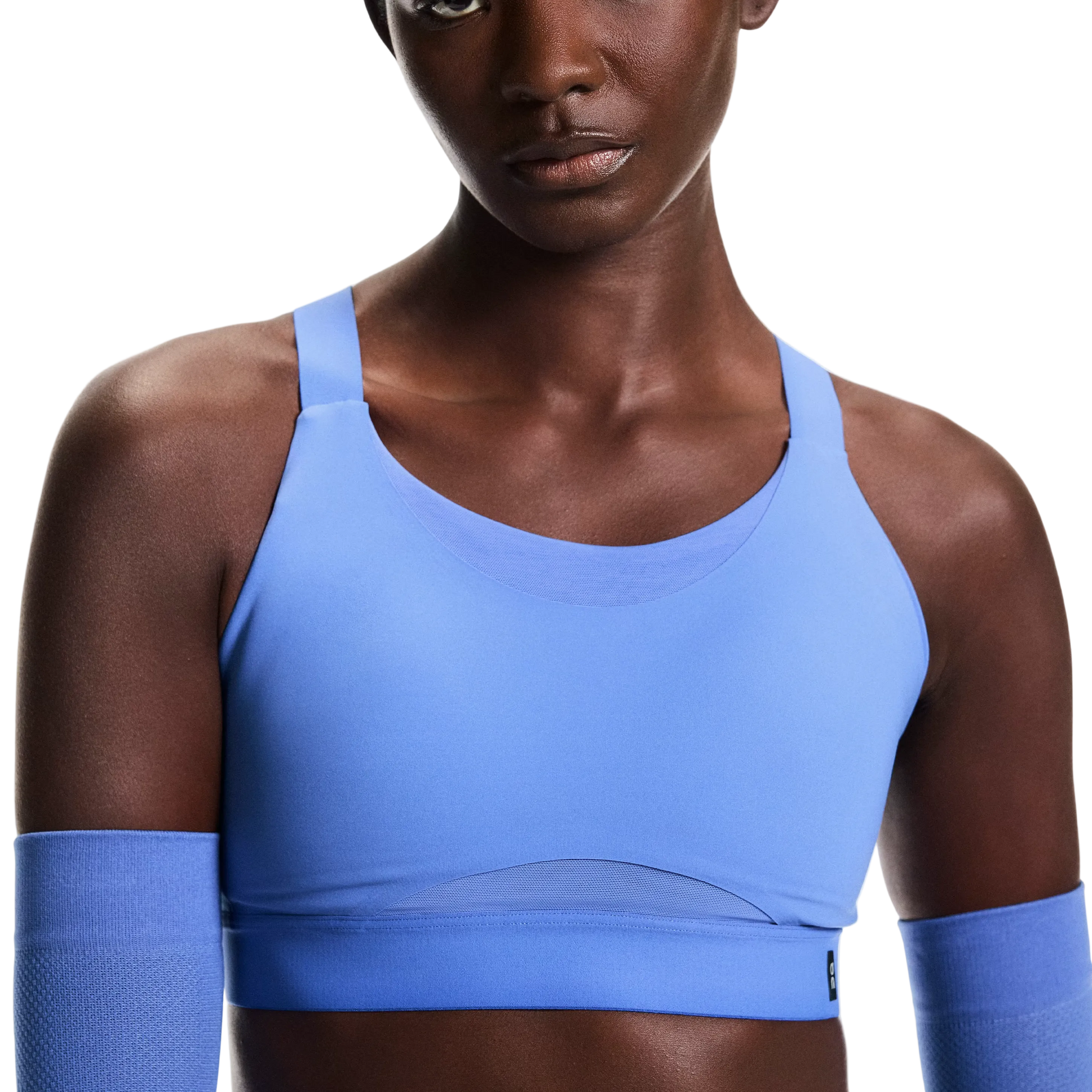 Person wearing a blue sports bra and arm sleeves on a white background